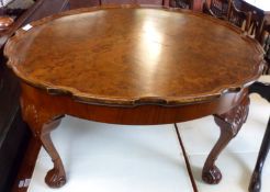 A reproduction Burr Walnut veneered Coffee Table with round scalloped top, raised on four heavy