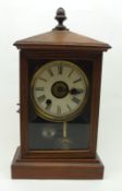 A small stained Wood cased Mantel Clock with Alarm movement, in a spun Brass bezel, acorn finial and