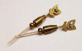 A pair of mid grey precious metal Stickpins (one only stamped.585), the finials shaped as stylised