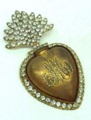 An unusual gilt metal heart shaped Wall Mounted Locket, encrusted with faux Diamonds to plume and