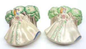 A pair of Clarice Cliff Crinoline Lady Wall Pockets, decorated with a Lady amongst trees, 7” high.
