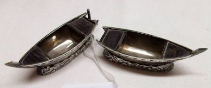 A pair of Far Eastern white metal Models of boats on stylised cast wave bases, 2 ¾” long, (one