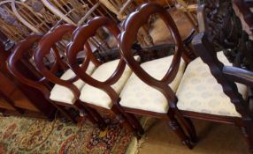 A set of four Victorian Mahogany balloon back Dining Chairs, raised on turned front legs,