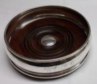 An Elizabeth II large Wine Coaster of plain circular form, turned Treen centre, initialled “WOBC” to