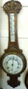 An early 20th Century Oak Wheel Barometer, with scroll and foliate moulded pediment, over a