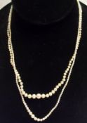 Two graduated natural Pearl Necklaces, one with Diamond set clasp, the largest Pearl on each