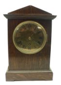 An early 20th Century Oak cased Timepiece, with arched top over moulded pediment, circular face with