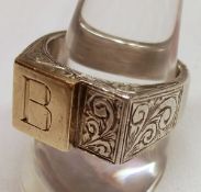 A heavy unmarked white metal Signet Ring with stepped yellow metal panel to the front, engraved with