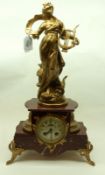 An early 20th Century French gilt metal figural and Marble Mantel Clock, crested with a classical