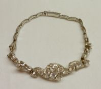 An unmarked precious metal Bracelet set with twenty-one graduated Diamonds, approximately 3 ct