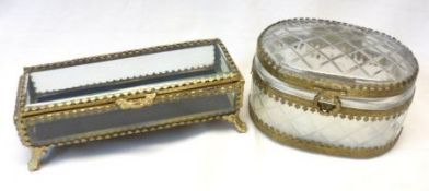 Two 20th Century gilt metal mounted Glass Trinket Boxes, one of oval facetted form, the other of