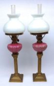 A pair of small Victorian Oil Lamps with square bases to a Brass Corinthian type column, opaque pink