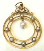 An Edwardian period yellow metal circular open work Pendant set with Seed Pearls and with Pearl