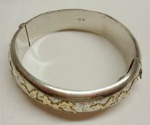 An early Elizabeth II hallmarked Silver Bangle of hollow section, the front with raised decoration