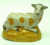 An early 19th Century Thomas Fell of Newcastle under Lyne Model of a recumbent Ewe, on an oval