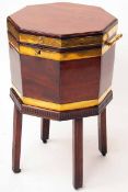 A George III Mahogany Wine Cooler, octagonal shaped, Brass coopering to body and top, the Table base