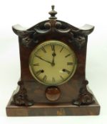 A Walnut cased Mantel Clock with central ball finial and scroll moulded face, with Brass bezel below