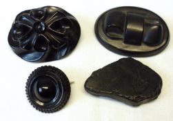 A packet containing two oval Jet Brooches, a circular example and a piece of natural Jet (conditions