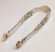 A pair of mid 18th Century Sugar Tongs, the cast and pierced arms with shell bowls, to an engraved