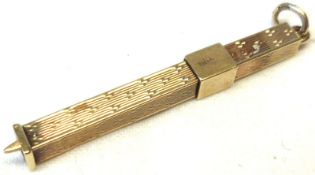 A hallmarked 9ct Gold Retractable Tooth Pick of square section, engine turned decoration, ringlet
