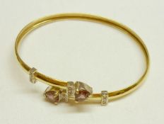A high grade precious metal Torc design Bangle featuring two heart shaped Amethysts and twelve white