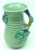 A Clarice Cliff Newport Pottery single handled Vase, decorated with embossed floral design on a