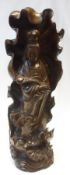 A 20th Century Hardwood Carved Figure of Guanyin standing before a Tobacco Leaf, 16” high.