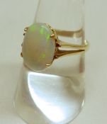 A high grade precious metal oval shaped Opal Ring with pierced shoulders, stamped “18ct”.