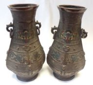 A pair of Japanese Bronze two handled Vases of ovoid baluster form, applied on either side with ring