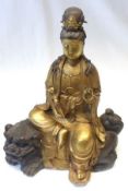 A 20th Century gilded Bronze Model of a seated Deity, seated on Bronze patinated Kaolin clutching