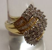 A hallmarked 18ct Gold designer type Ring of cross over design, brilliant cut and baguette cut