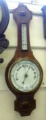 An early 20th Century Mahogany Wheel Barometer with moulded pediment, over a double scale