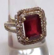 A mid grade precious metal Ring set with a centre emerald cut Ruby, approximately 5.5ct, the ruby