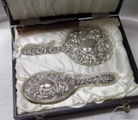 An Elizabeth II cased three piece Silver backed Dressing Table Set comprising: Hand Mirror and