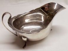 An Elizabeth II Sauce Boat of usual Georgian style, with card cut rim, looped handle and supported