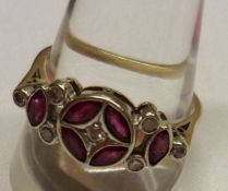 A yellow metal Ring featuring a circular front panel of four small Rubies with centre small Diamond,