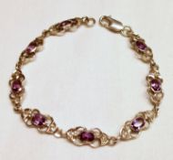A white metal filigree link Bracelet set with purple and white stones.