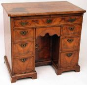 An early 18th Century Walnut Kneehole Desk, the top with quartered veneering, to a cross banded