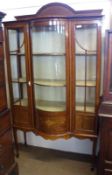 An Edwardian Mahogany Sheraton Revival Display Cabinet with three doors, the central bowed glazed