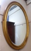 A large late 19th Century oval bevelled Wall Mirror in gilt finished frame, 40” high.