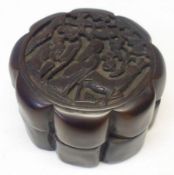 A Chinese Scribes Treen Ink Box of shaped circular form, the lid embossed with figures and