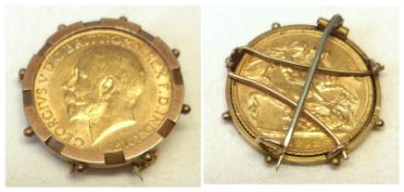 A George V Gold Sovereign within a yellow metal Brooch Mount, stamped “9ct”.