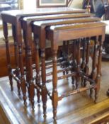 A nest of four early 20th Century Mahogany Tables with carved floral decorated frieze, on turned