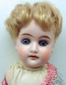 An early 20th Century unmarked Bisque Head and Shoulder Plate Doll with fixed blue glass eyes,