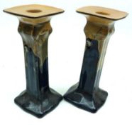 A pair of Royal Doulton Candlesticks, decorated in a blue design of a monk in cellar, signed Noke, 6