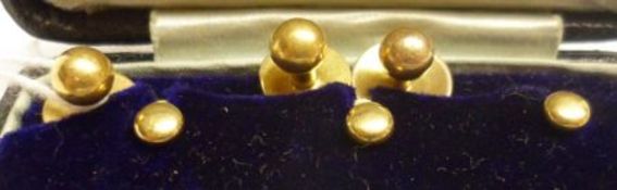 A cased set of three high grade yellow metal Dress Studs, 10mm diameter, stamped “18ct” and weighing