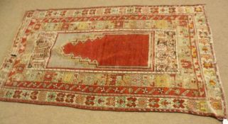 A Caucasian Prayer Rug with triple gull border, central plain iron red panel and the borders with