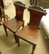 A pair of mid-19th Century Mahogany Hall Chairs, the tapering backs with carved detail to a plain