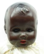 Early 20th Century German Black Bisque Head Baby Doll, with brown glass eyes, painted brows and