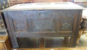 An 18th Century and later adapted Oak Coffer, the three panelled top with later carving, the front